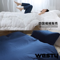 圖片下方展示藍色床鋪，上方是睡在白色被子裡的女人，被子上印有「四國纖維販售」及「WESTY」字樣。