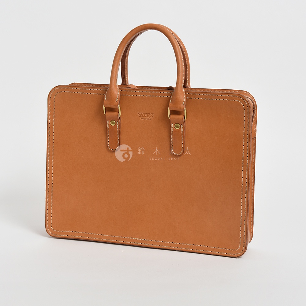 職人手作皮革手提商務公事包，經典駝色，以堅固的縫線裝飾，搭配雙皮革提把與金色金屬扣環。