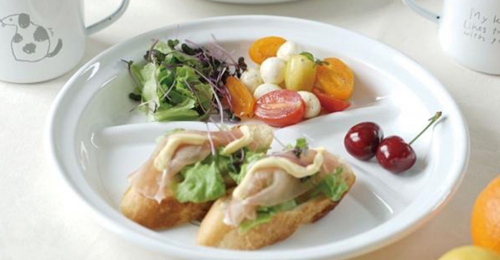 CAT&DOG 琺瑯分隔餐盤，白色圓形，內有三個分隔，盛有沙拉、番茄、迷你莫札瑞拉起司球、小巧的三明治，以及兩顆櫻桃。