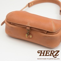 職人手作皮革大容量扣環郵差包，焦糖棕色，採用柔軟皮革製成，搭配復古金屬扣環和車縫線設計。