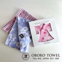 視覺描述模式 三條日式花紋毛巾，其中兩條為淡紫色碎花圖案，一條為紅色條紋搭配紅色圓點，置於白色禮盒旁。