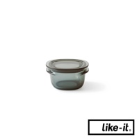 一個帶有密封蓋的透明灰色圓形保鮮盒，材質看起來是玻璃或塑膠，底部有品牌標誌。