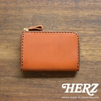 棕色皮革拉鍊短夾，帶有金色拉鍊，邊緣縫線精緻，整體簡約大方，展現職人手作質感。