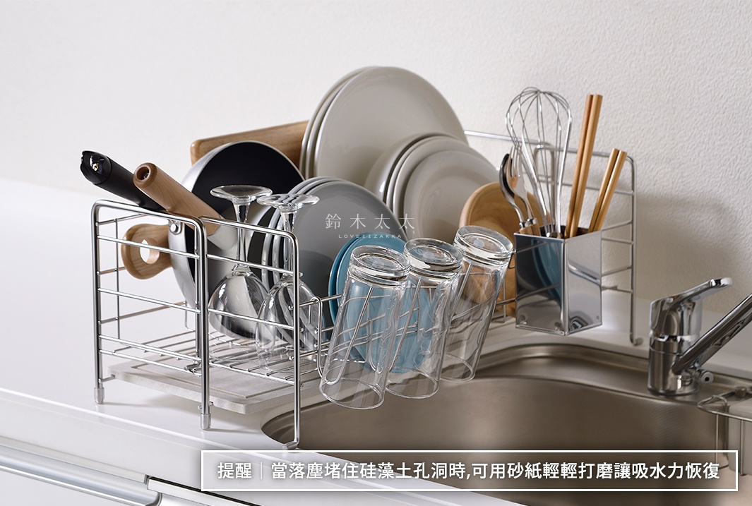 銀色金屬材質的珪藻土伸縮式碗盤瀝水架，架上擺放著多個盤子、玻璃杯、鍋子、木柄鍋鏟、打蛋器和筷子。