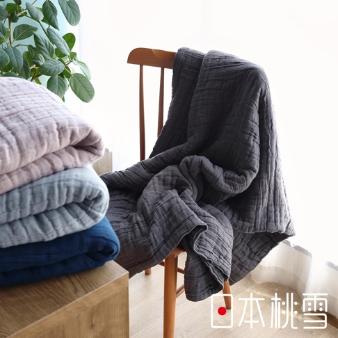 八層紗透氣被，圖片展示深灰色被子搭在木椅上，旁邊堆疊粉色、淺灰色和藍色被子。