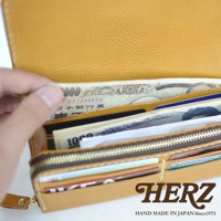 職人手作皮革長夾，黃褐色，內部裝有日圓鈔票與多張信用卡，展示寬口設計與大容量收納空間。