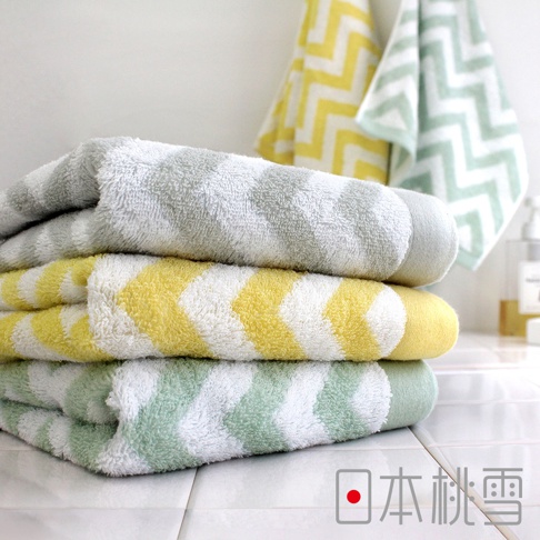 今治北歐浴巾，三條疊放，由上至下分別為淺灰色、黃色與白色相間的鋸齒紋，以及淺綠色與白色相間的鋸齒紋。材質柔軟，適合日常使用。