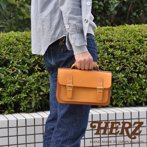 職人手作皮革雙扣兩用迷你肩背包，焦糖棕色，採用真皮材質，設有兩個金屬扣環和提把，可手提或肩背。