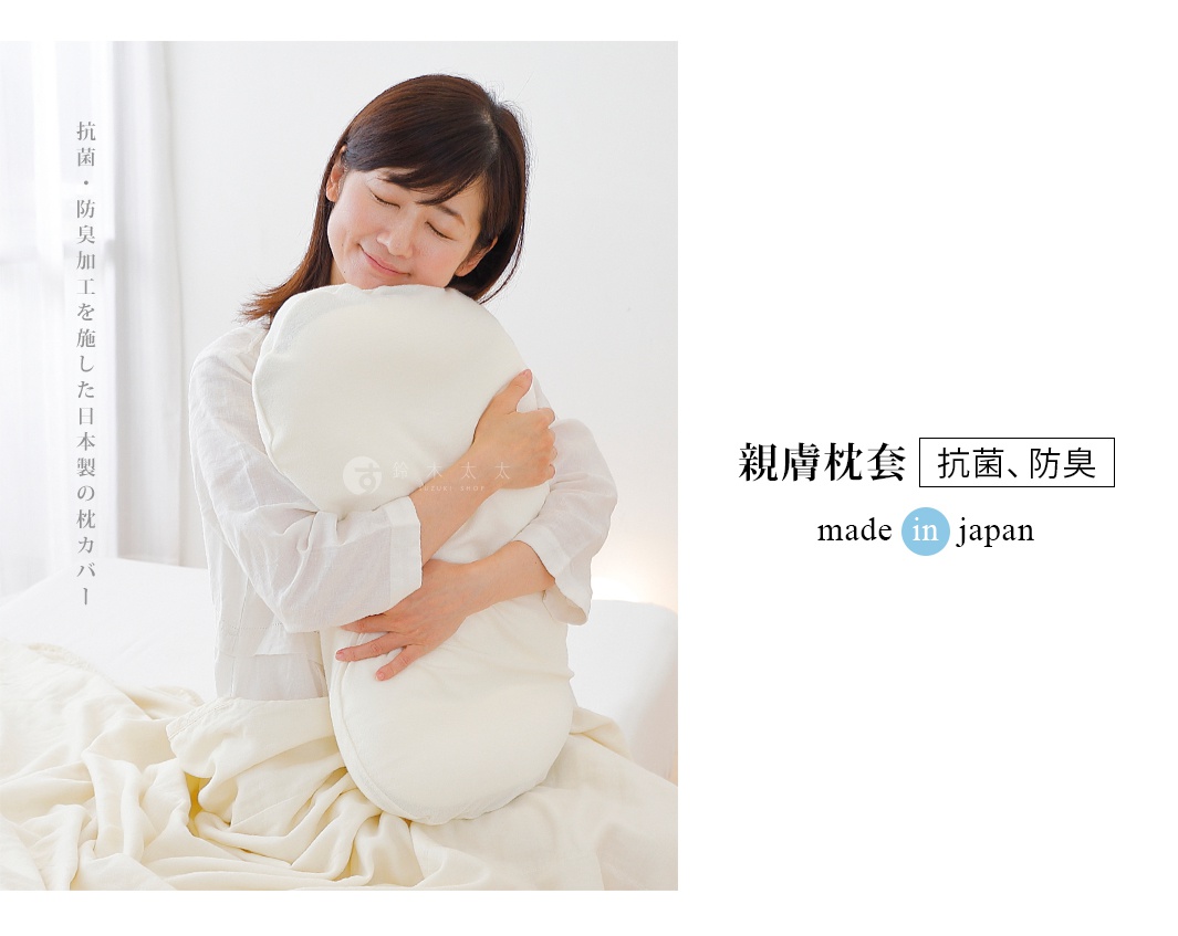 一位女性抱著一個奶油色圓形枕頭，枕頭套看起來是柔軟的棉質。