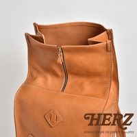 職人手作皮革後背包，淺棕色，拉鍊開合，帶有品牌標誌，適合露營登山使用。