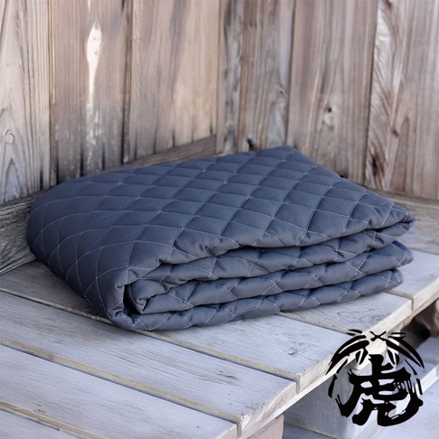 深灰色菱格紋鋪棉床墊，材質為竹炭纖維，單人尺寸，疊放於木質表面。