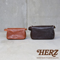 兩款職人手作皮革Organ斜背包，一款為棕褐色，另一款為深棕色，皆為方形設計，搭配可調式皮革繫帶與金色金屬扣環。