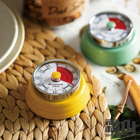 黃色與綠色的美式復古造型磁吸機械式計時器，圓形錶盤，白色底面，標示分鐘刻度，紅色區域顯示剩餘時間，中間有黃色旋鈕。