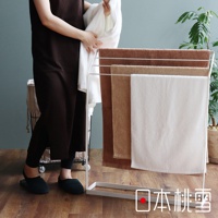 白色金屬毛巾架上掛有多條飯店方巾，顏色包含深棕色、淺棕色和白色。方巾材質看起來柔軟吸水，適合居家或飯店使用。