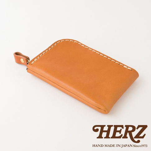 日本HERZ手工製作皮革迷你錢包，採用淺棕色Stare皮革製成，表面有白色縫線細節，左側配有金色鉚釘與皮革拉環，整體呈現簡約精緻的質感。