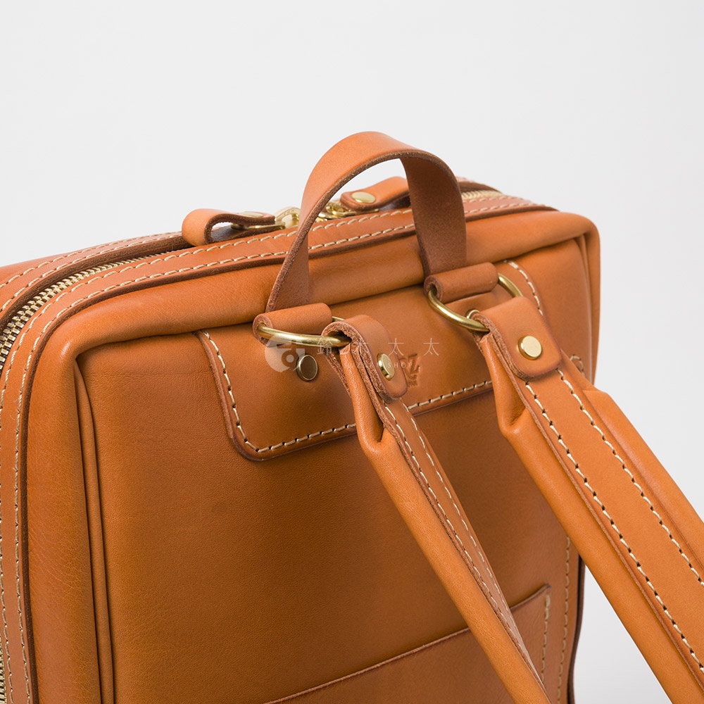 職人手作皮革軟皮商務後背包 R-28，展示為棕色皮革材質，帶有金屬拉鍊與圓環，以及精緻的縫線細節。