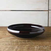 Tsudoi 赤飴釉美濃燒圓盤，呈現深棕色，表面光滑，具有光澤感，盤緣略微向上彎曲，置於木質桌面和白色木板背景上。