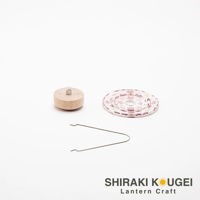 木製燈座，上方有銀色金屬頂飾。旁邊是捲起的白色圓形提燈，印有粉紅色碎花圖案。底部有一對銀色金屬夾子。