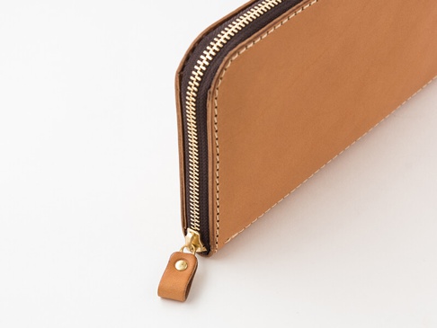 職人手作皮革長夾，淺棕色皮革，搭配金色拉鍊和同色系皮革拉頭，車縫線整齊，設計簡潔大方。