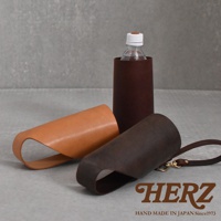 職人手作皮革Organ水壺套，展示深棕色、淺棕色和紅棕色三款。其中紅棕色水壺套內裝有透明水壺，淺棕色和深棕色水壺套則平放在旁邊，展示其皮革質感與結構。