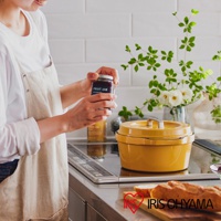 黃色 COCO 萬用無水調理鍋 24cm，帶有銀色提把，置於爐灶上，旁邊有一罐果醬和裝飾用花束。