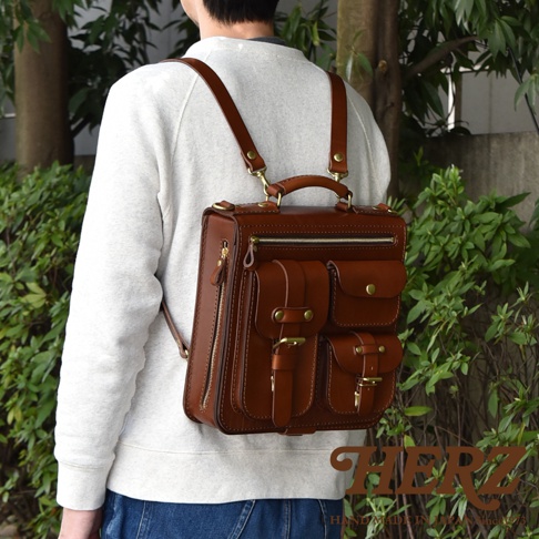 職人手作皮革三口袋三用後背包，深棕色皮革，設有頂部提把、可拆卸式肩帶、多個外口袋和拉鍊開合。