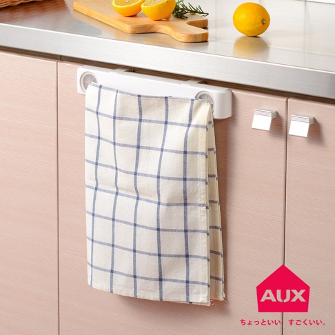 白色兩用收納袋架掛在淺木色櫥櫃門上，架上掛著一條米白色格紋的毛巾。