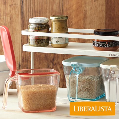 LIBERALISTA 調味料罐收納架上擺放著各式的罐頭醬料、調味品，前方還有透明的儲物罐。