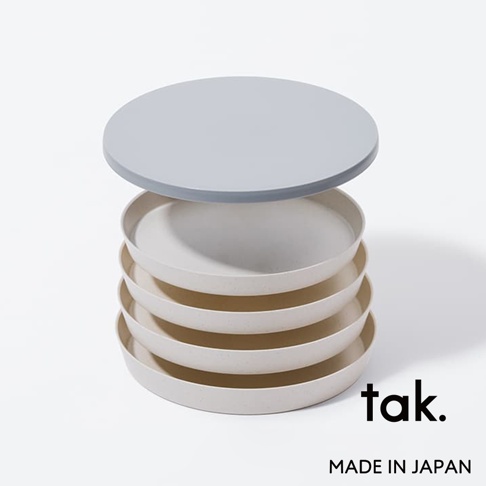 FIT DISH 餐盤四件組，由淺米色材質製成，疊成一疊，最上方蓋著一個淺灰色圓形蓋子。