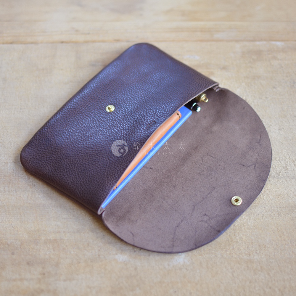 職人手作深棕色皮革鈕扣式小物收納袋，袋內可見一支筆，材質為皮革，尺寸為中型。