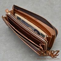 職人手作皮革Organ大容量拉鍊長夾，內部可見一疊日圓千元鈔票，多個夾層設計，拉鍊部分為深棕色，整體皮革顏色為淺棕色。