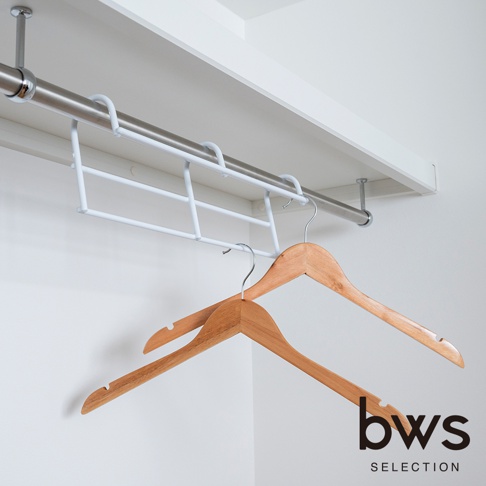 一個安裝在白色衣櫃吊衣桿上的 bws SELECTION 白色金屬掛架，掛架設計為高低錯位結構，下方懸掛著兩支木質衣架，整體風格簡約現代。