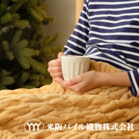 米色波浪紋細絨毯，質地柔軟，觸感舒適，搭配條紋上衣與白色馬克杯，營造溫馨居家氛圍。