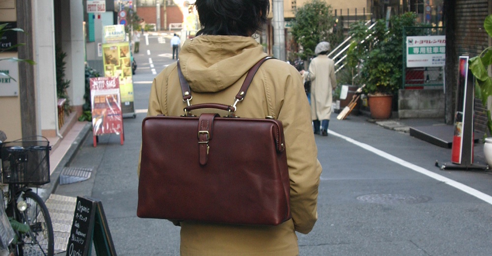 職人手作皮革軟式杜勒斯包，深棕色，設有頂部提把、可調節肩帶及鎖扣。