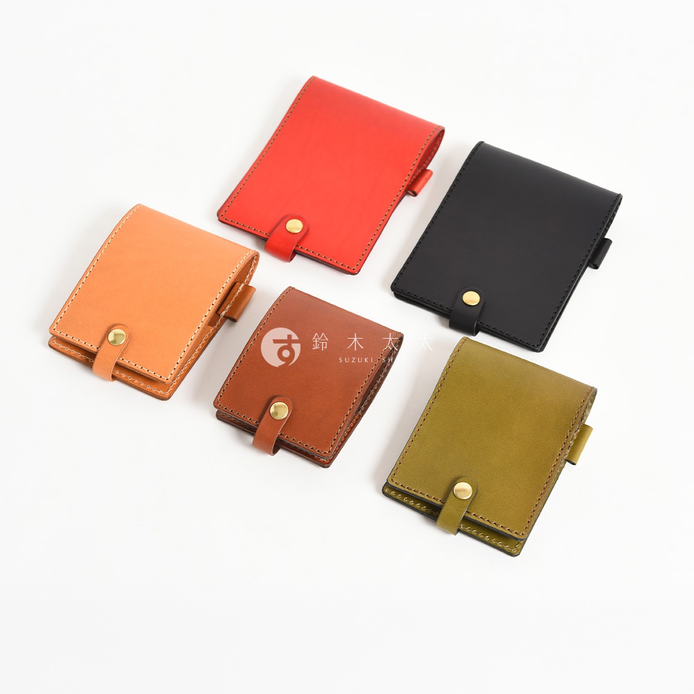 五款職人手作皮革便利貼收納套，分別為紅色、橘色、棕色、黑色及橄欖綠，皆為方形設計，採用皮革材質，並以金屬釦環固定。