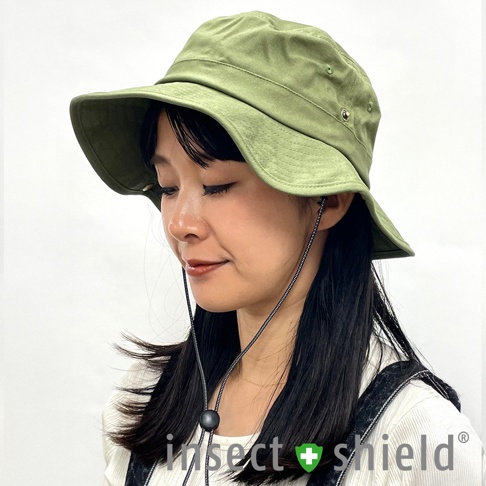 一位女性佩戴著一頂軍綠色、寬邊的機能漁夫帽，帽緣有兩個金屬透氣孔，帽下有可調節的防風繩。