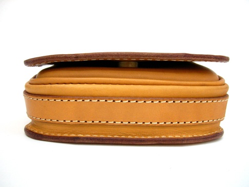 職人手作皮革翻蓋直式單肩包 (CP-96)，採用自然色澤皮革，搭配精緻縫線，呈現簡約復古風格。包身側邊特寫，展現皮革的質感與工藝。