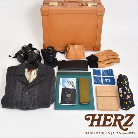 職人手作皮革英倫風便攜手提行李箱 TR-1，搭配棕色皮革小物，包含相機、鏡頭、錢包、護照、手套、圍巾及雨傘。