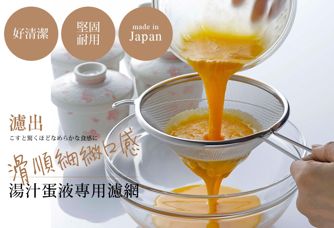不鏽鋼錐型濾網，細網孔設計，用於過濾蛋液。濾網為銀色金屬材質，帶有兩個握把，置於透明玻璃碗上方。