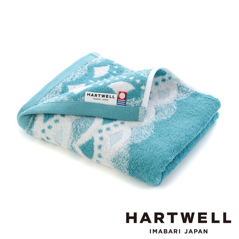 一條藍綠色棉質毛巾，以白色傳統和風紋樣織成，毛巾表面柔軟，帶有品牌標籤，標籤上印有「HARTWELL IMABARI JAPAN」字樣。