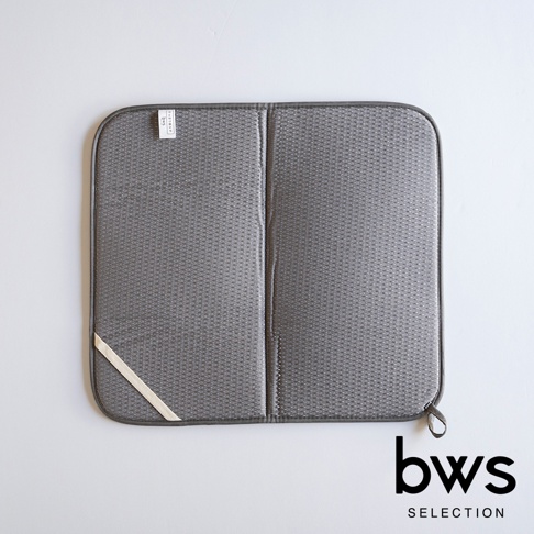 可折疊收納瀝水墊，灰色，表面有細小的網狀紋理，兩邊有深灰色的包邊。左側角落有一條淺色織帶。