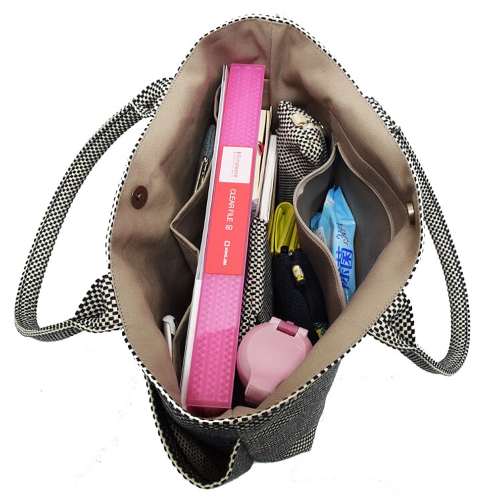 三河木綿刺子織手提托特包 L，黑色格紋圖案，內部有分隔袋，裝有文件夾、書本、筆、濕紙巾和粉色小藥盒。