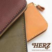 職人手作皮革經典拉鍊長夾，展示深棕色、軍綠色與焦糖色皮革，搭配金色拉鍊。