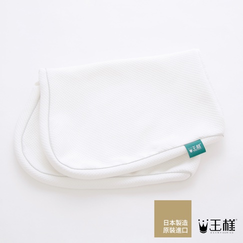 白色天絲緹花枕套，表面有細緻的菱格紋理，邊緣以灰色滾邊裝飾。枕套一角縫有綠色品牌標籤，標示「王樣®」。