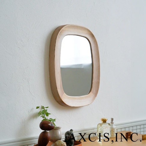 橢圓形鏡面，鑲嵌著質樸的淺色木框，鏡框邊緣呈現圓潤曲線，掛於紋理牆面。