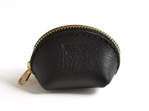 黑色皮革貝殼造型零錢包，配有金色拉鍊和拉環，表面壓有品牌標誌。