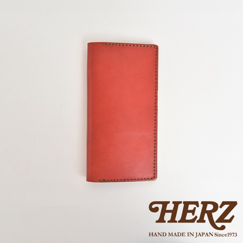 職人手作皮革旅行記事本書套，採用橘紅色皮革，邊緣有精緻的縫線裝飾。