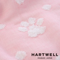 粉色今治純棉紗布浴巾，織有白色立體點點（肉球）圖案，材質輕柔透氣。