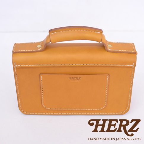 職人手作皮革經典兩用雙扣迷你單肩包，淺棕色，質感光滑的皮革材質，包面有縫線裝飾，正面有一個方形外袋，印有品牌Logo。