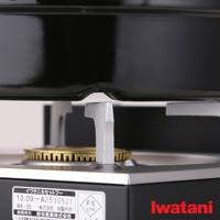 卡式爐專用網狀烤盤，黑色烤盤下方有銀色金屬支架，支架上方的圓形爐頭有黃銅色金屬防風環。